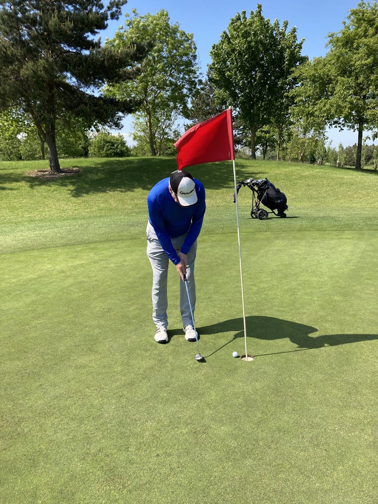 A man plays golf on a sunny day in Dublin, Ireland's lush green course.