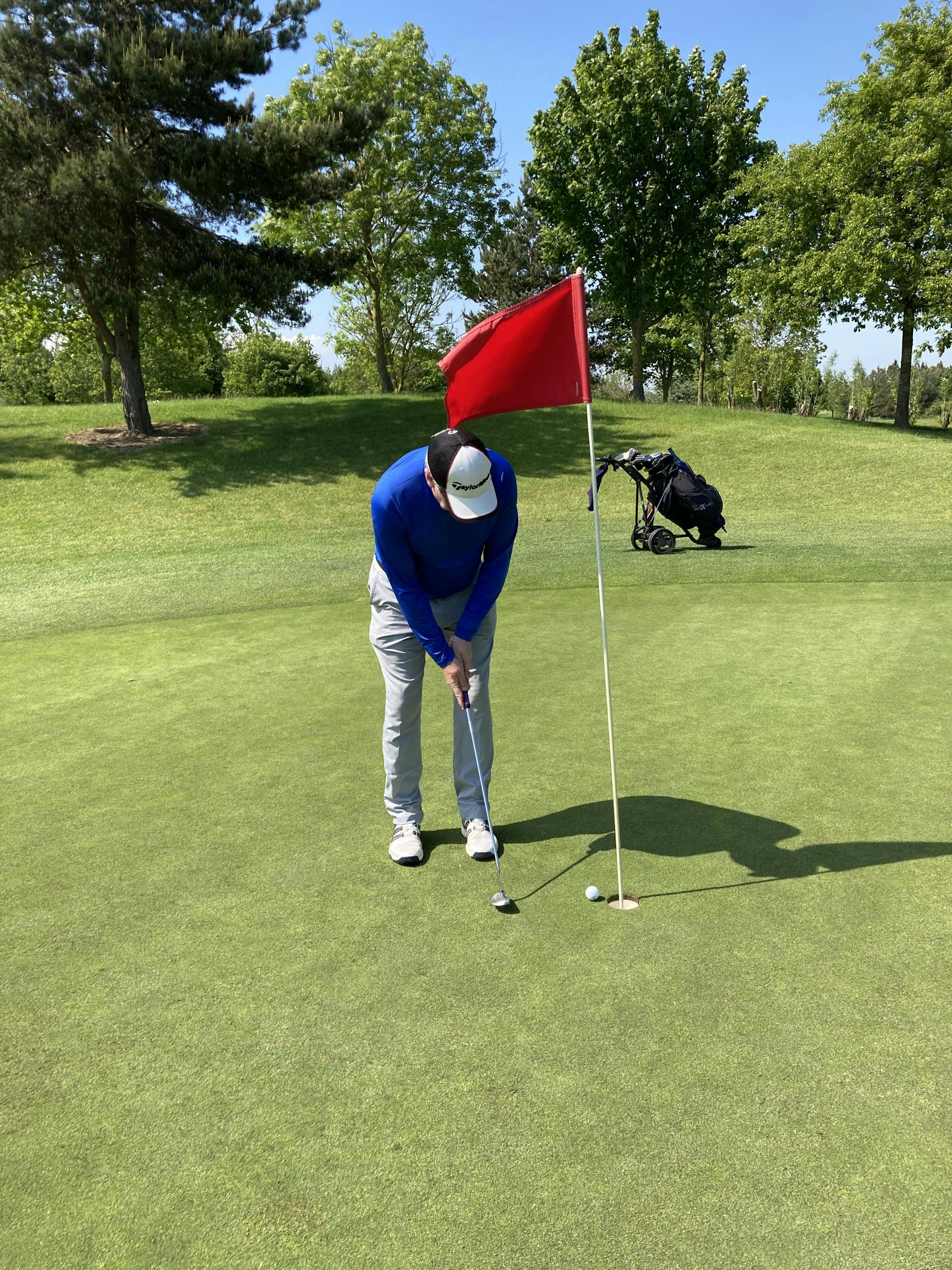 A man plays golf on a sunny day in Dublin, Ireland's lush green course.