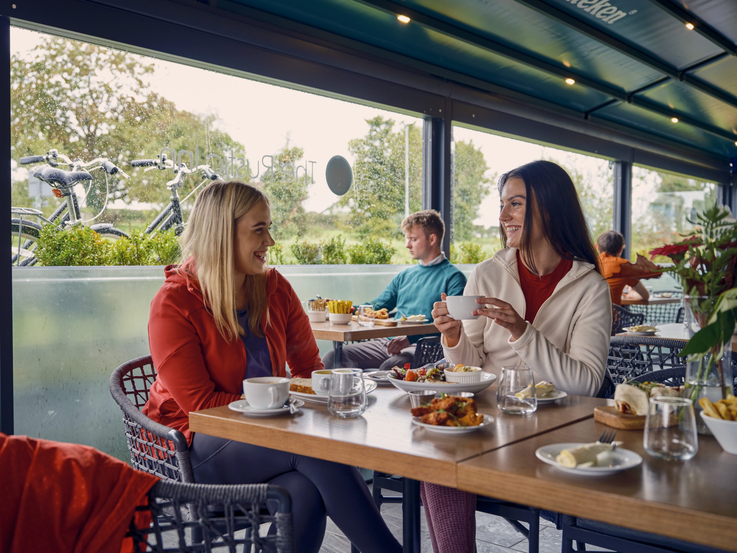 Two women enjoying food and drink indoors near the royal canal longford
